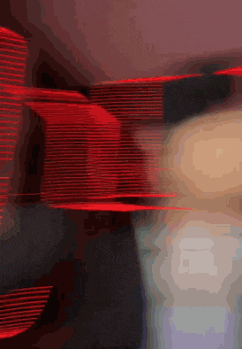 a blurry picture of a person 's face and a red light behind them