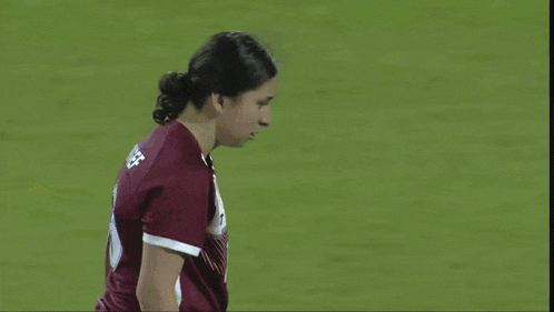 a soccer goalie catches a soccer ball in front of a net