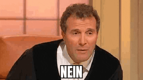 a man in a judge 's robe is sitting in front of a window with the word nein on his face .