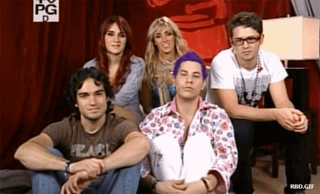 a group of people are sitting in front of a sign that says pg on it