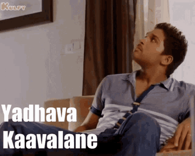 a man is sitting on a couch with the words vadhava kaavalane written on the bottom