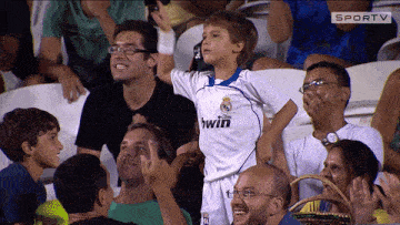 a young boy in a bwin jersey stands in the stands
