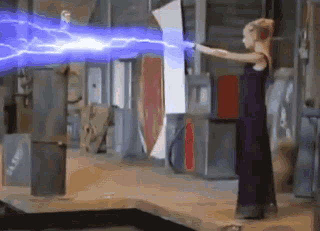 a woman in a black dress is holding a lightning bolt in her hand .