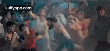a group of people are dancing and playing drums in a dark room .