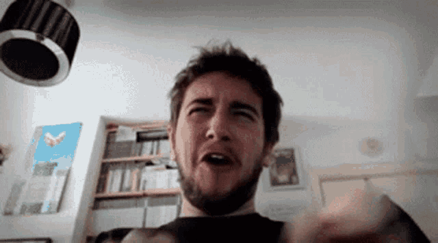 a man with a beard is making a funny face in a living room