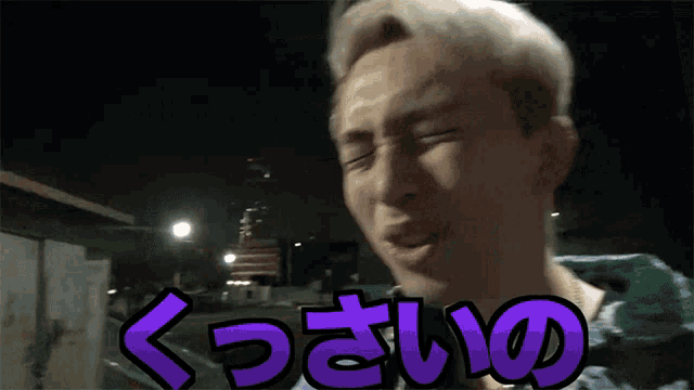 a man is making a funny face with purple letters that say " x "