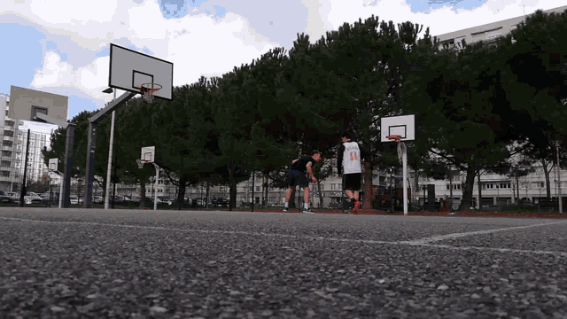 two young men are playing basketball on a court
