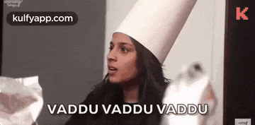 a woman wearing a chef 's hat is holding a piece of paper and saying vaddu vaddu vaddu .