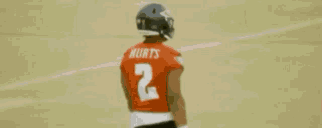a football player wearing a red jersey with the number 2 on it .