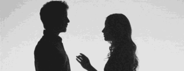 a silhouette of a woman holding a man 's hand in a black and white photo .