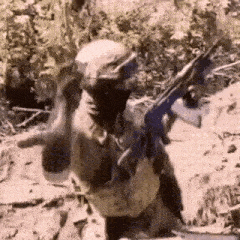 a man in a mask is holding a gun in his hand in a field .