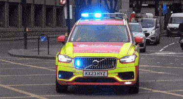 a red and yellow volvo with a license plate that says kx23hyz