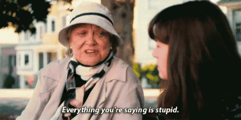 an elderly woman in a hat is talking to a young girl and saying `` everything you 're saying is stupid . ''