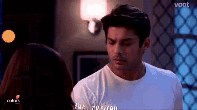 a man and a woman are looking at each other in a room .