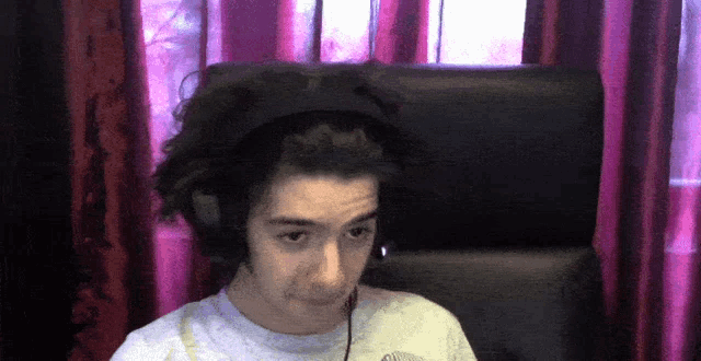 a man wearing headphones sitting in front of a microphone