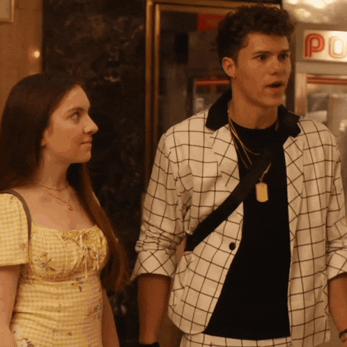 a man in a plaid jacket is standing next to a woman