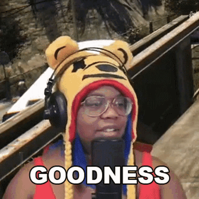 a woman wearing a winnie pooh hat and headphones says goodness