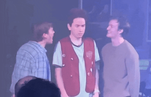 three young men are standing next to each other on a stage .
