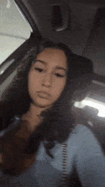 a girl is taking a selfie in the back seat of a car .