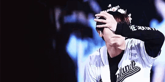 a man with a flower crown on his head is wearing a jersey that says ' oakland ' on it