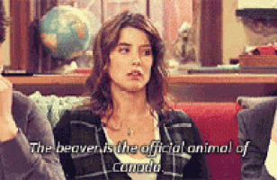 a woman is sitting at a table with a man and a globe in the background and says the beaver is the official animal of canada