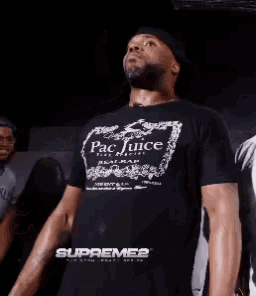 a man wearing a pac juice t-shirt is dancing
