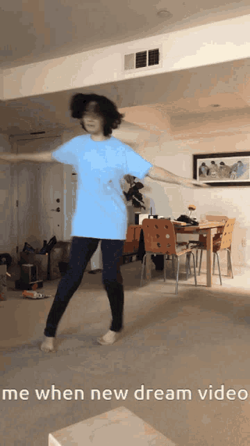 a person in a blue shirt is dancing in a living room with the words me when new dream video below them