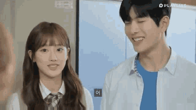 a boy and a girl are standing next to each other in a room and smiling .