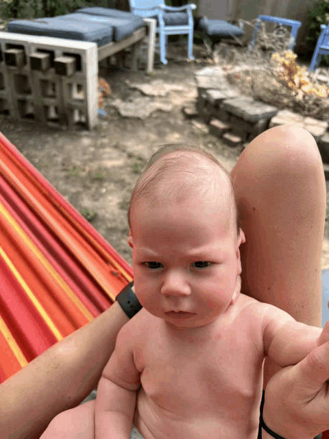 a baby without a shirt is being held by a person
