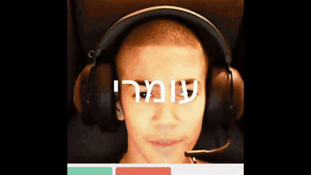 a man wearing headphones with a microphone on his head has the word ' i ' on his forehead