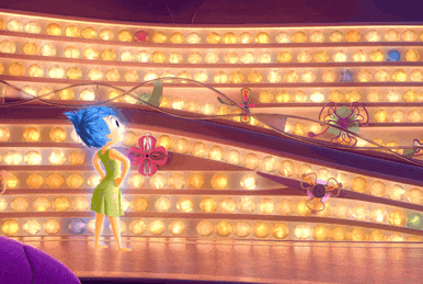 a girl in a green dress is standing in front of a wall of lights