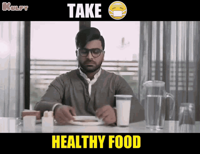 a man sitting at a table with a glass of milk and a plate of food with the words take healthy food below him