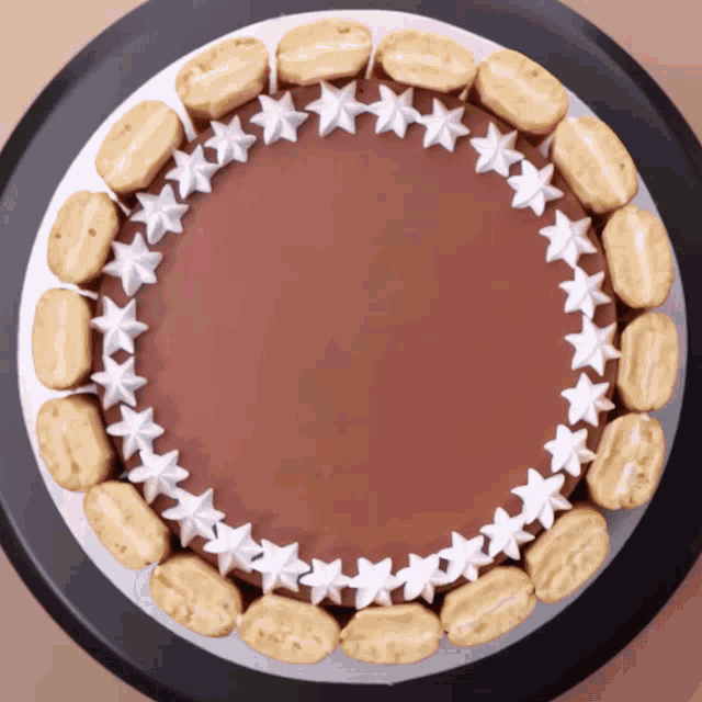 a chocolate cake with white frosting and a circle of cookies
