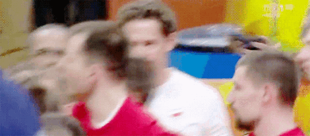 a blurry picture of a group of men standing around each other .
