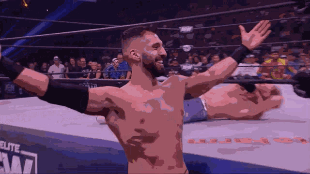 a man in a wrestling ring with his arms outstretched in front of a sign that says athlete am