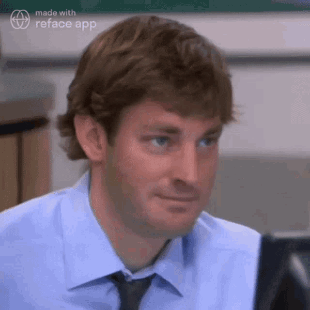 a man in a blue shirt and tie is sitting in front of a computer .
