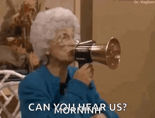 an elderly woman is holding a megaphone in her mouth and talking into it .