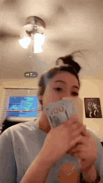 a woman is holding a stack of 100 dollar bills