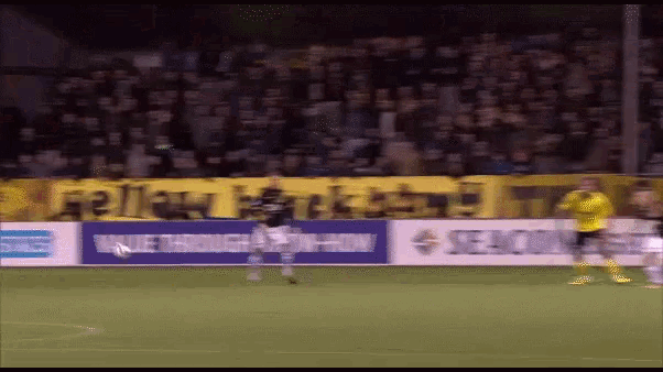 a soccer game is being played in front of a banner that says ' seacom '