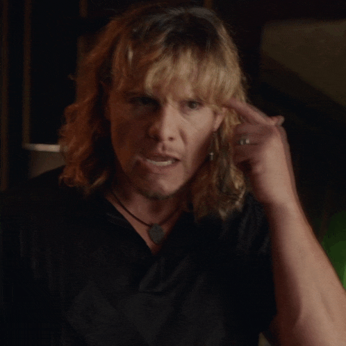 a man with long blonde hair wearing a black shirt