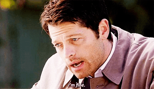 a man in a trench coat and tie is saying i 'm fine .