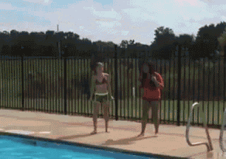 two girls in bikinis are standing next to a pool