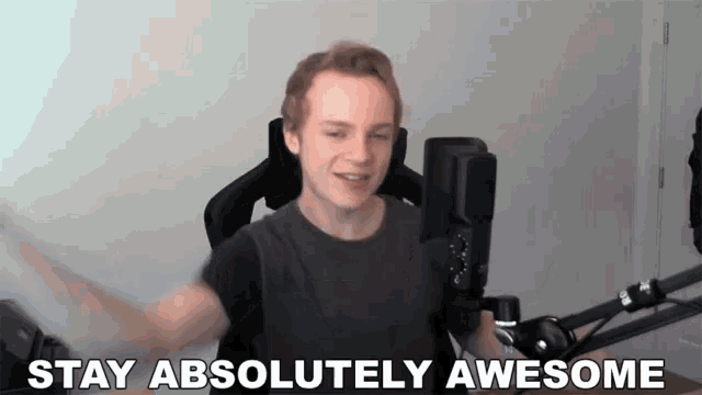 a man is sitting in front of a microphone and saying stay absolutely awesome