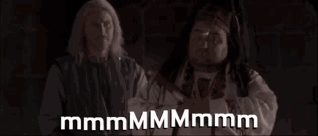two men are standing next to each other with a caption that says mmmmm