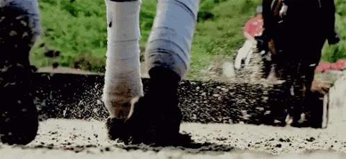 a close up of a person 's feet walking in the mud