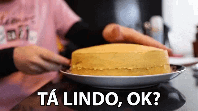 a person putting a cake on a plate with the words ta lindo ok