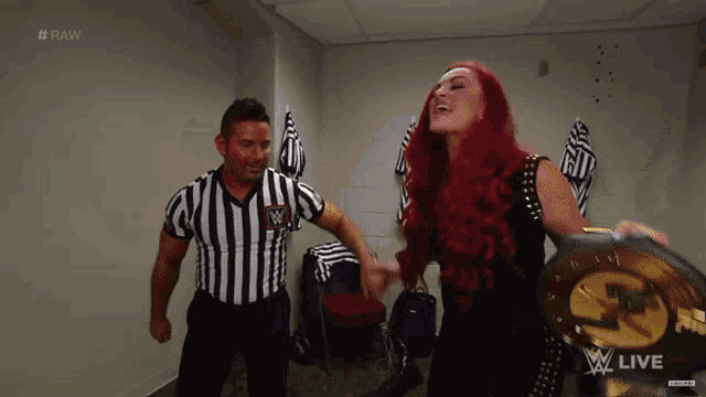 a woman with red hair is standing next to a referee who is wearing a striped shirt with a w on it