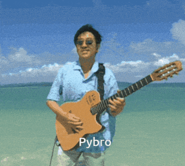 a man is playing a guitar on the beach and the name pybro is below him