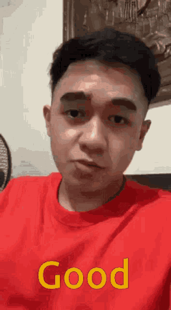 a man wearing a red shirt that says good