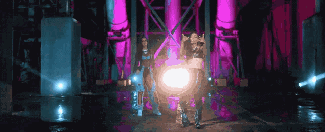 a couple of women standing in front of a bright light